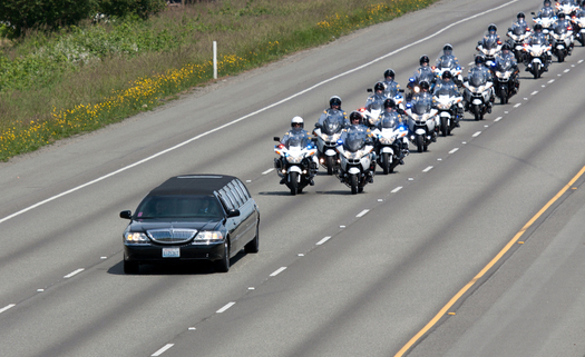 Police on motorcycle escort a hearse carrying a fallen police officer at a recent funeral. (njp/iStockphoto)
