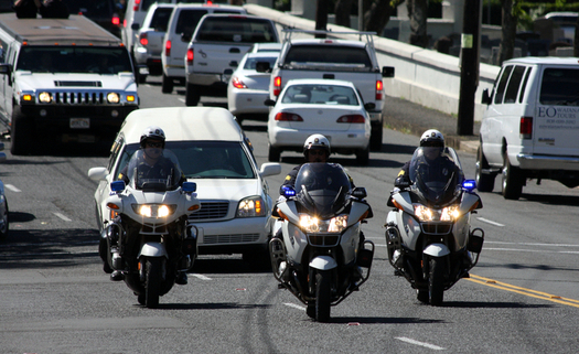 A trio of motorcycle officers leads the funeral procession for a fellow  officer recently killed in the line of duty. (Hako/iStockphoto)