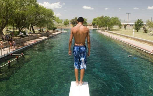 A swimmer prepares to dive into the cold, clear water of the pool at Balmorhea State Park. (Texas Parks and Wildlife photo)