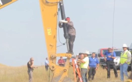 Happi American Horse chains himself to construction equipment at an August protest of the Dakota Access Pipeline. (Desiree Kane/Wikimedia Commons)