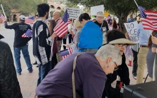 Protesters sang patriotic songs in front of Sen. John McCain's office in Tucson to protest immigration raids. (Indivisible Southern Arizona)