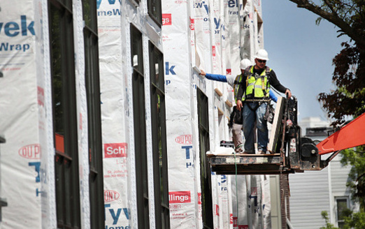 Construction workers put the finishing touches on new townhouses in Dallas. The high cost of housing is making it difficult for low-income Texans to find an affordable home. (ScottOlson/Getty Images)