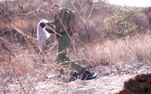 A video still from January 2017 shows a Border Patrol agent removing a blanket left for migrants. (No More Deaths)