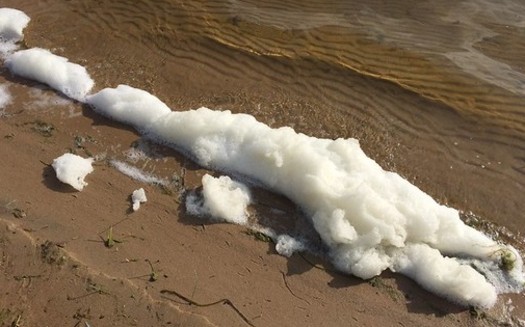 Contaminated foam gathers on Van Etten Lake near the former Wurtsmith Air Force Base. (Michigan DEQ/Flickr)