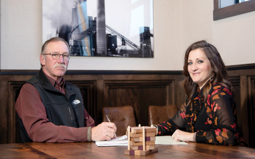 Christie Obenauer (R), president and CEO of Union State Bank of Hazen, meets with Matt Clarys (L) of Western Steel Builders. Partnering with the Bank of North Dakota, Obenauer's small bank has been able to finance several large projects in her town. (Justine Wiedrich)
