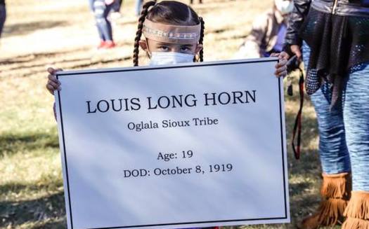 A young girl holds the name of an Indigenous teen tied to a former Native American boarding school in Rapid City. (SiouxSanLands)