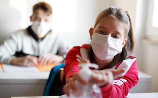 Arkansas researchers say face masks, combined with vaccinations and proper handwashing, can help keep COVID cases down in school settings. (Adobe Stock)