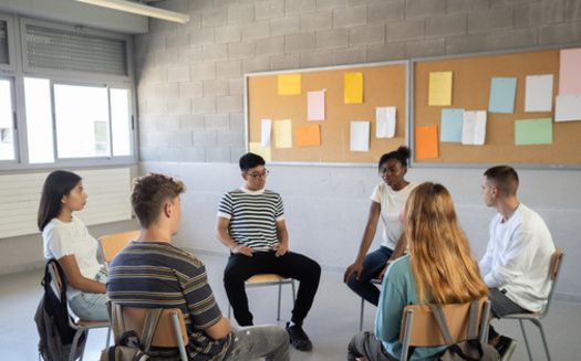 Beyond direct counseling, school social workers will sometimes hold group discussions with students as they try to cope with a tragic incident on campus. (Adobe Stock)