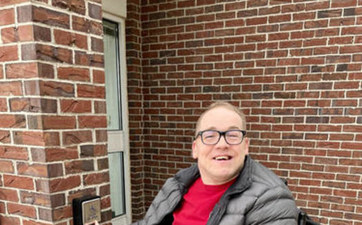 Robert Fisher, residente en Adel, Iowa, consiguió que se instalara un botón electrónico para abrir la puerta de la oficina de correos local. (Robert Fisher, Consejo de Iowa sobre Discapacidades del Desarrollo)