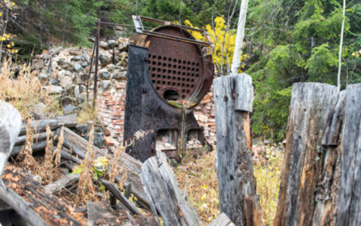 Remnants of a stamp mill briefly used to process ore from the Highland Chief Mine that operated within yards of the Yellowstone Park northern boundary from 1894 to 1908. Fine mine tailings likely eroded soil and washed into Yellowstone National Park via the Yellowstone River. (William Campbell/Greater Yellowstone Coalition)