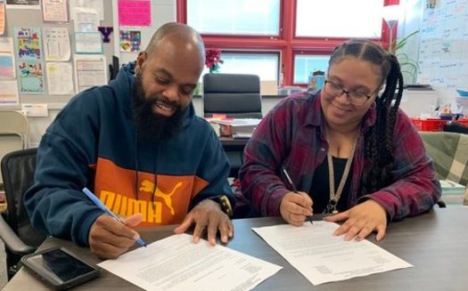 Jermaine Bailey and daughter ShaWanna sign their letters of job offers with the city of York's school district. Both are certified teachers and will start in the Fall. (Courtesy Jermaine Bailey)