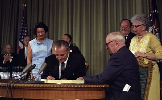 Former President Harry Truman was present when President Lyndon Johnson enacted Medicare. (White House Press Office)