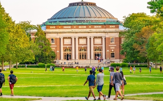 College students walk on the quadrangle lawn of the Foellinger Auditorium on the University of Illinois campus in Urbana. (Adobe Stock)