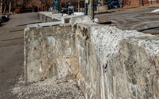 Extremes of hot and cold weather have taken their toll on a concrete barrier along Binghamton's Riverwalk. Concrete crumbles between the stones of the wall in upstate New York. (Chet Wiker/Adobe Stock)