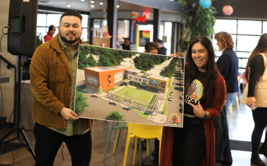 Attendees at a recent COPAL event hold the design of a proposed Latino Center for Community Engagement in the Twin Cities. The organization hopes to have the facility up and running by 2026. (Photo courtesy COPAL)