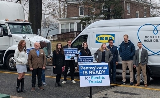 Members of the Cleans Trucks Philadelphia Coalition stand in front of clean energy-powered electric trucks and vans during a Philadelphia news conference on Tuesday. (The Partnership Project)
