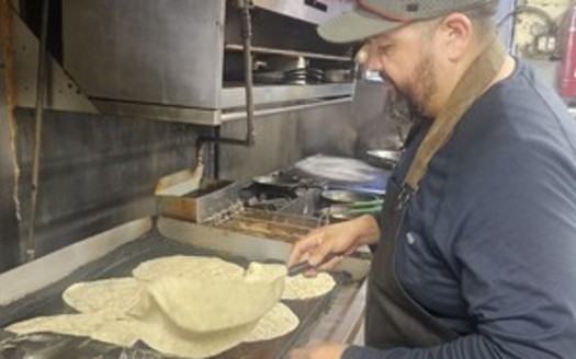 Volunteer Hector Silva of Hunger Action Los Angeles prepares burritos for distribution to fire victims in Pasadena, Calif. (Sara Donis)