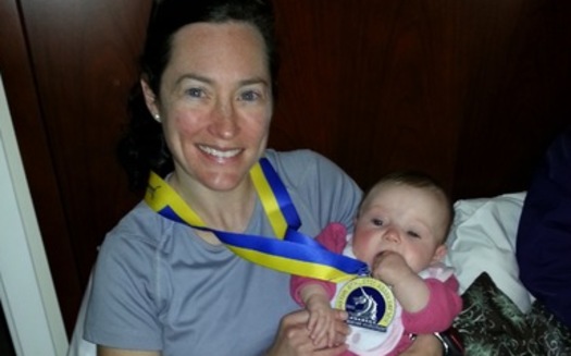 PHOTO: Mother Meredith Olsen, an Episcopal Priest from Baltimore, shows the medal she received from running in the Boston Marathon. She is pictured with her niece. Courtesy of Olsen. 