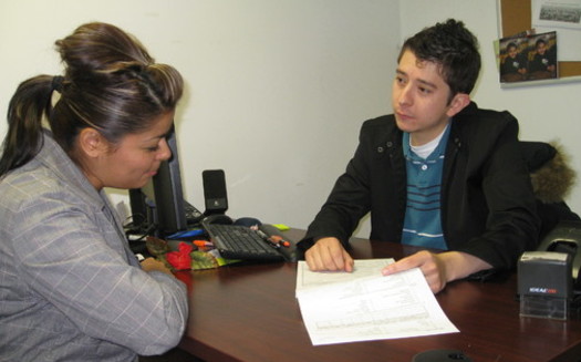 PHOTO: Utah's Community Health Centers are already accustomed to doing outreach work with patients. Here, AmeriCorps worker Erik Perez explains a CHIP application to a local mom. Courtesy AUCH. 