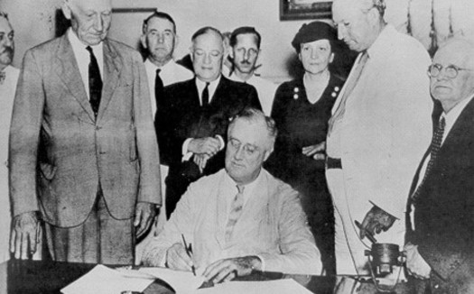 President Franklin D. Roosevelt, signing the original Social Security Act on August 14, 1935, calls it, 